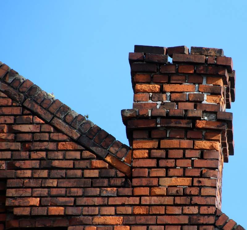 Damaged chimney on an Eagle Mountain home showing cracks and missing mortar